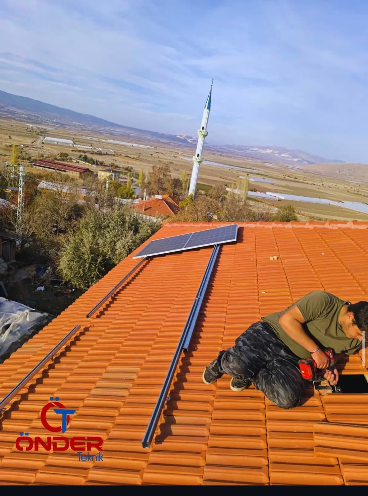Kiremit çatıya güneş paneli taşıyıcı rayları monte eden teknisyen