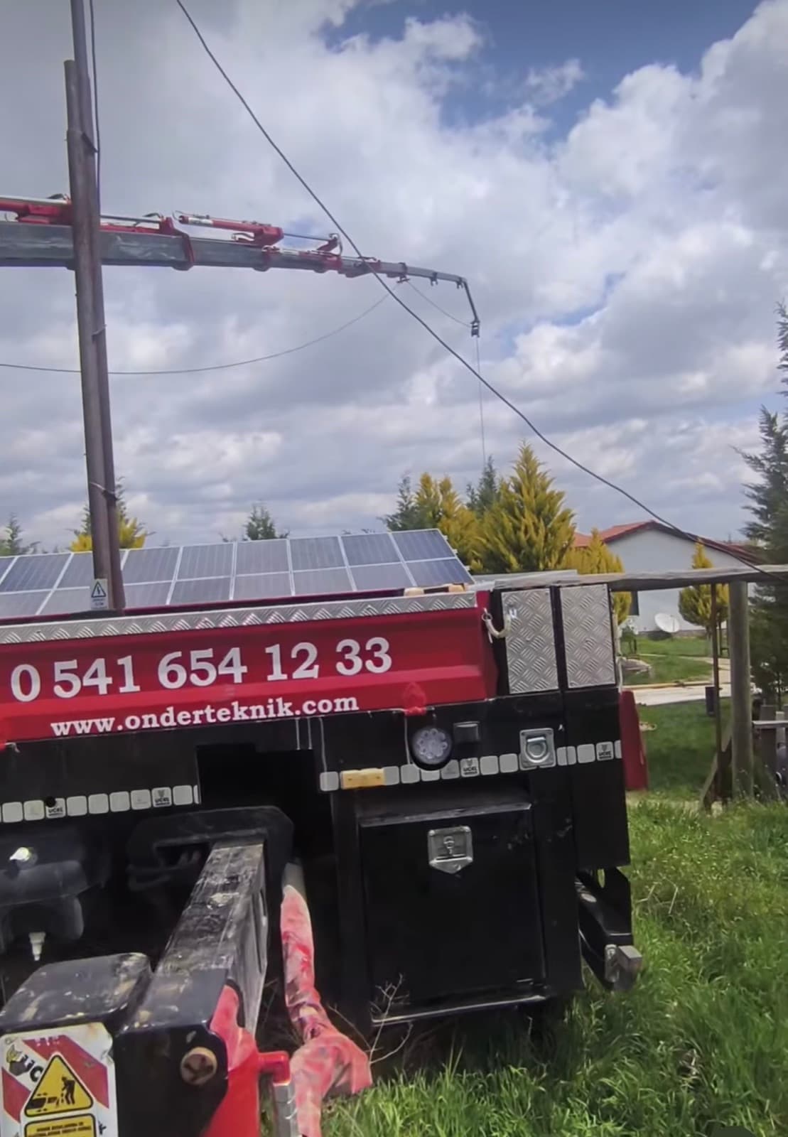 Vinç bomu, güneş panelleri önünde enerji direğine uzanıyor